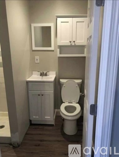 A bathroom with a toilet, sink, and medicine cabinet.