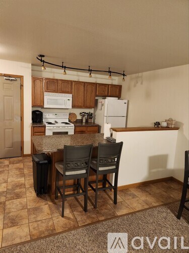 A kitchen with a white stove top oven and a white refrigerator.