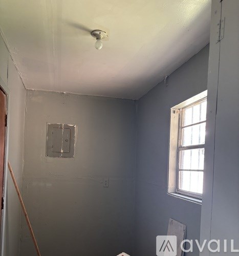 A room with a window and a light fixture on the ceiling.