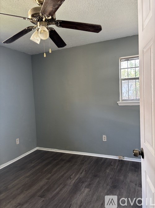 A room with a ceiling fan and a door.