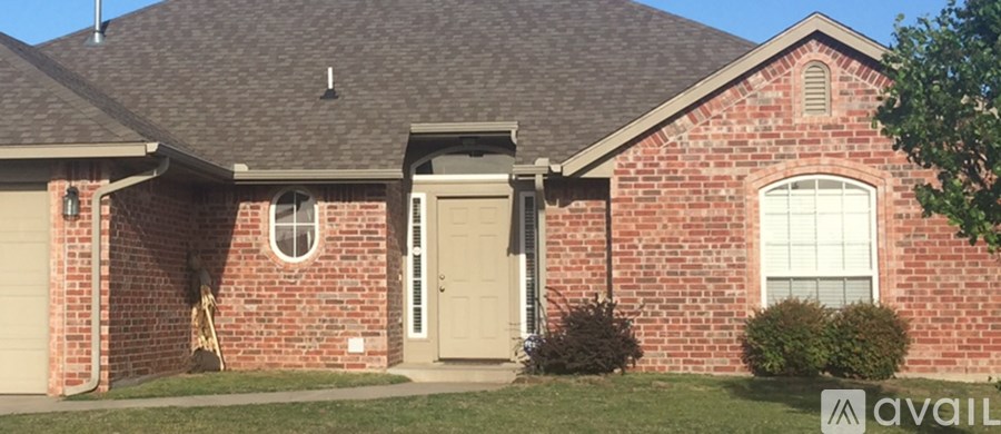 A red brick house with a white door and window.