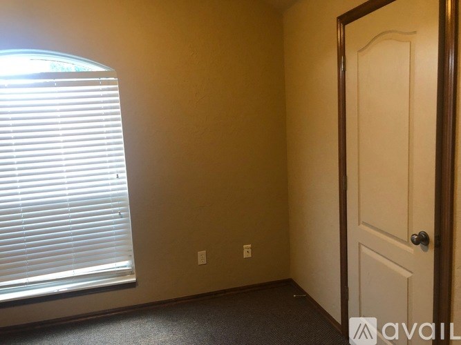 A room with a door, window, and a carpeted floor.