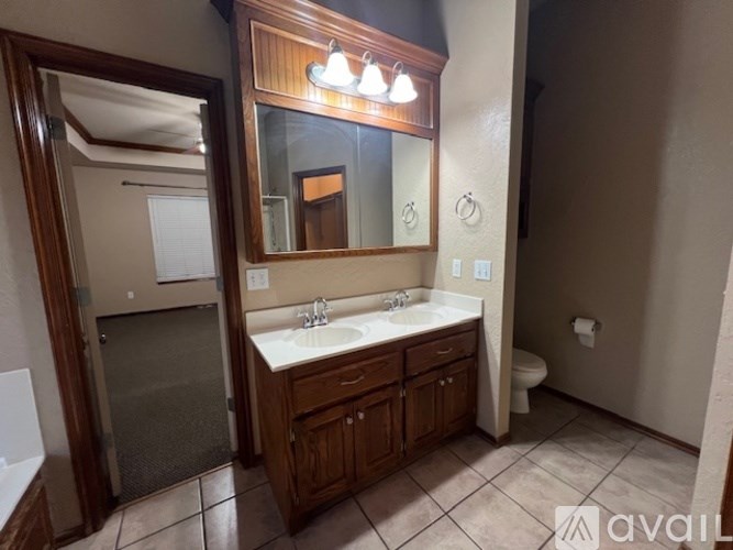 A bathroom with a sink, mirror, and toilet.