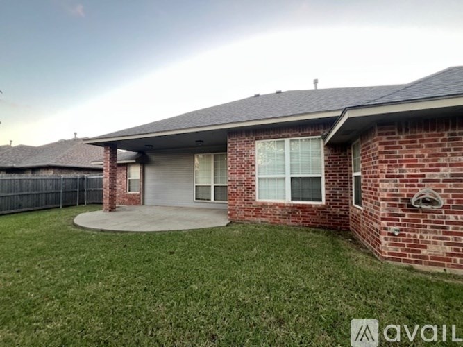 A house with a brick exterior and a grey roof is for sale.