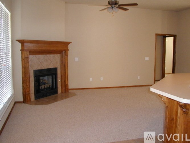A living room with a fireplace and a fan.