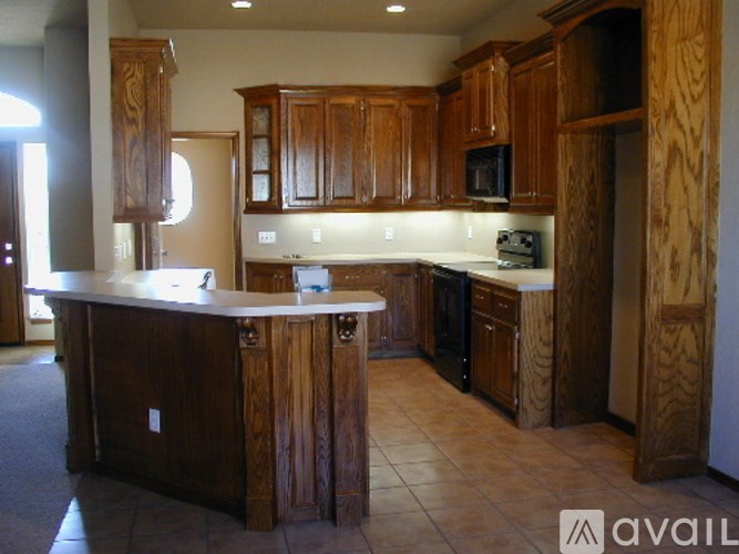 A kitchen with wooden cabinets and a white counter.