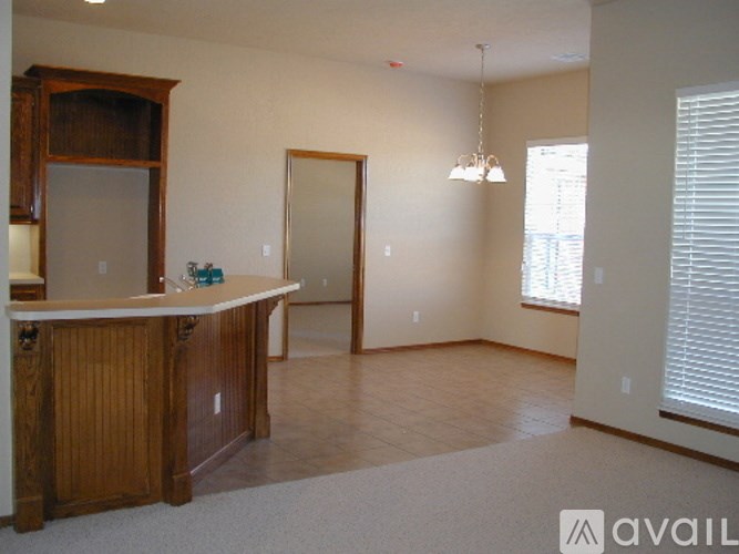 A room with a wooden cabinet and a white countertop.