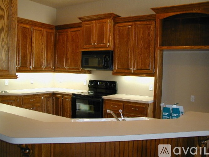 A kitchen with wooden cabinets and a black oven.