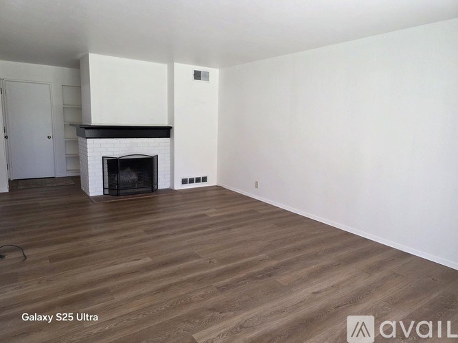 A room with a fireplace and wooden floors.