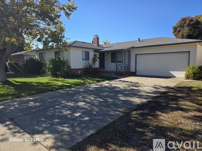 A house with a garage and a tree in front.