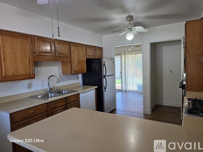 A kitchen with wooden cabinets and a black fridge.