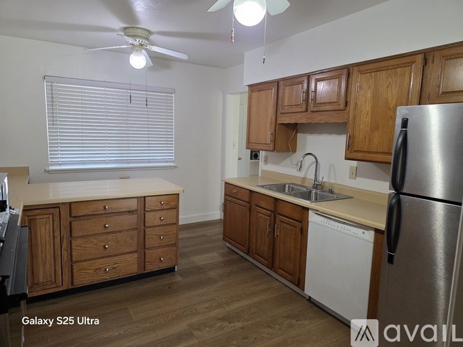 A kitchen with wooden cabinets and a white fridge.