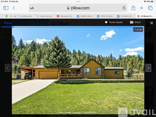 A yellow house with a garage is displayed on a real estate website.