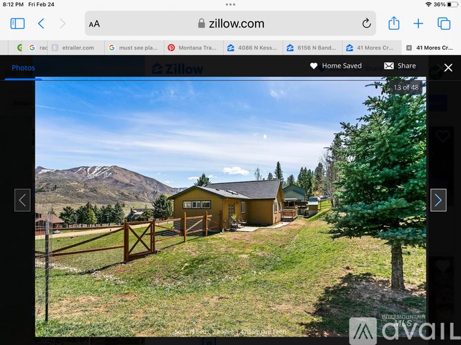 A yellow house with a mountain in the background.