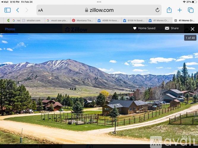 A mountainous landscape with a road and houses in the foreground.