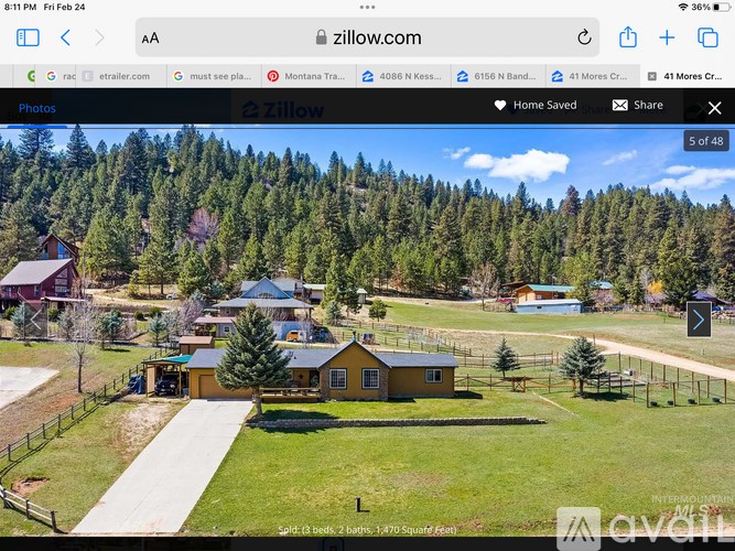 A webpage displays a real estate listing for a property with a yellow house and a forested background.