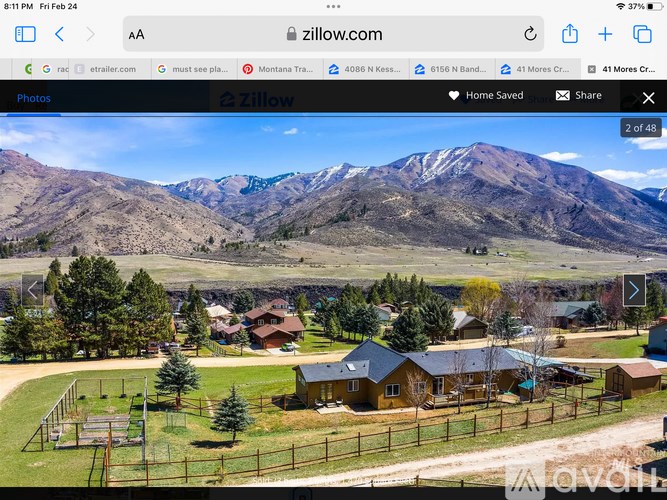 A real estate website is open and the page is showing a photo of a house in a neighborhood with a mountain in the background.