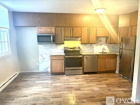 A kitchen with wooden cabinets and a stone backsplash.