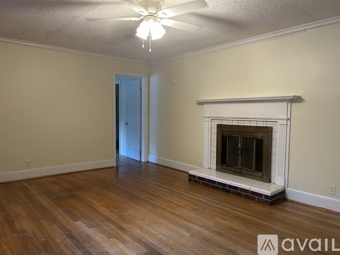 A room with a fireplace and a ceiling fan.