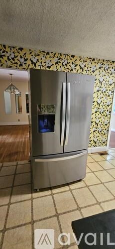 A stainless steel refrigerator with its door open in a kitchen.