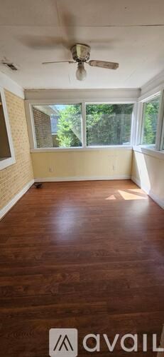 A room with a ceiling fan and wooden flooring.