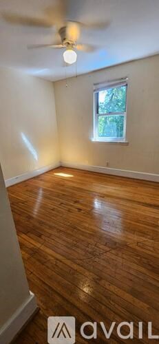 A room with wooden flooring and a ceiling fan.