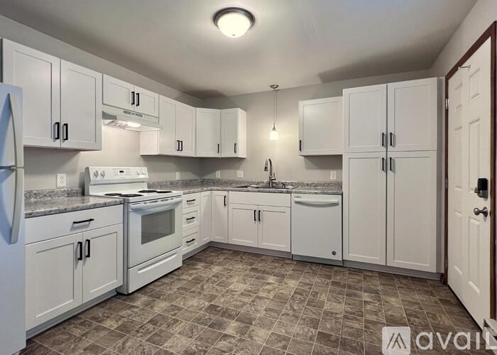 A kitchen with white cabinets and appliances.