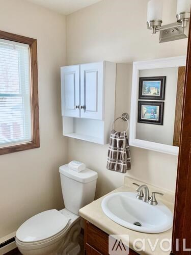 A small bathroom with a toilet, sink, and medicine cabinet.