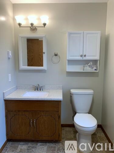 A bathroom with a toilet, sink, and medicine cabinet.