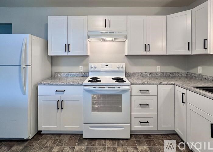 A kitchen with white appliances and cabinets.