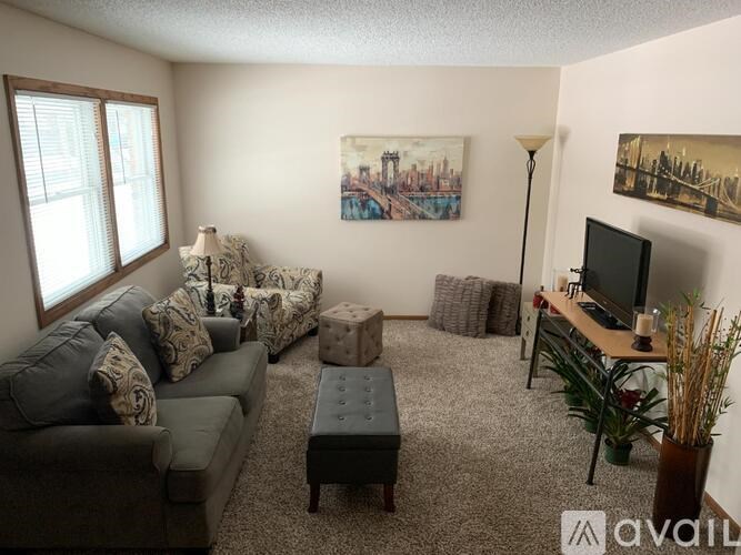 A living room with a grey couch, a coffee table, and a painting on the wall.