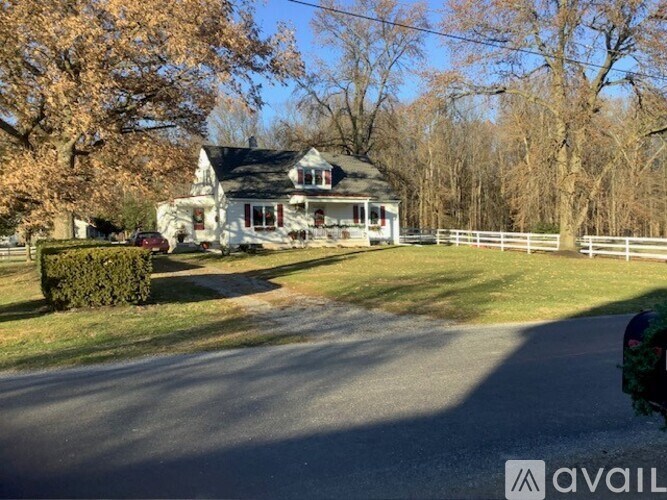 A house with a white fence and a tree with no leaves.