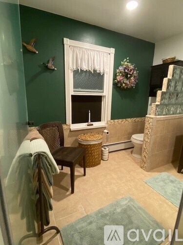 A bathroom with green walls and a window.