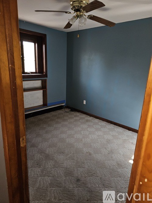 A room with a ceiling fan and a carpeted floor.