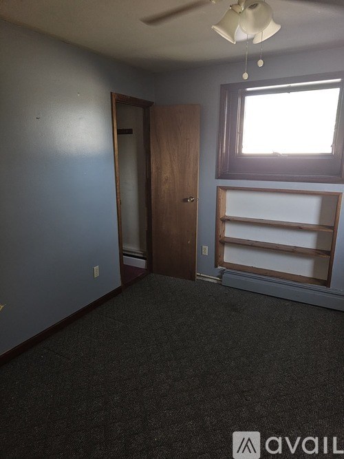 A room with a door, a window, and a ceiling fan.