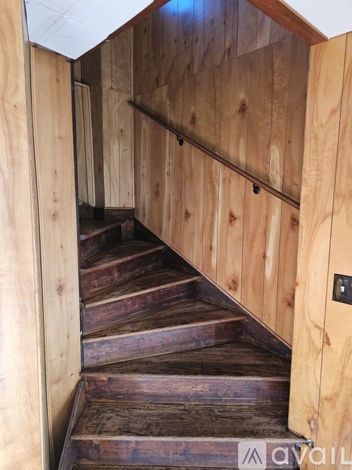 A wooden staircase with a metal railing.