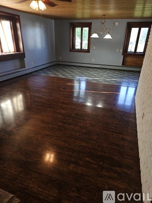 A room with wooden flooring and a ceiling fan.
