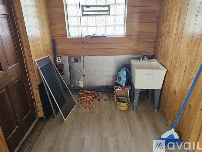 A room with wooden walls and a white sink.