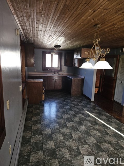 A kitchen with wooden cabinets and a checkered floor.