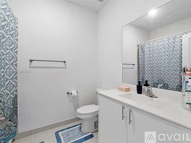A bathroom with a toilet, sink, and shower curtain.