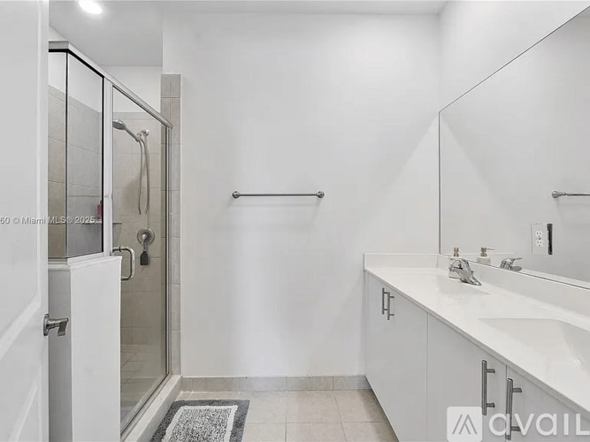 A white bathroom with a walk in shower and a sink.