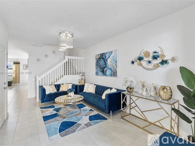 A living room with a blue sofa and a glass coffee table.
