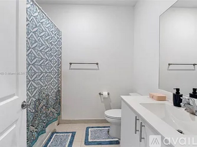 A bathroom with a toilet, sink, and shower.