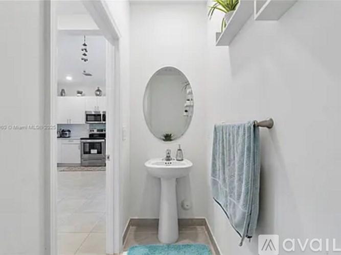 A bathroom with a white sink and a round mirror.