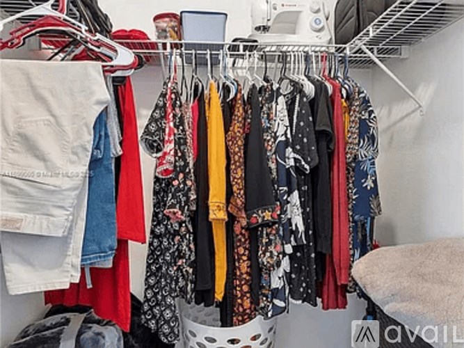 A rack of clothes in a closet.