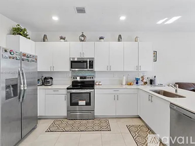 A kitchen with white cabinets and appliances.