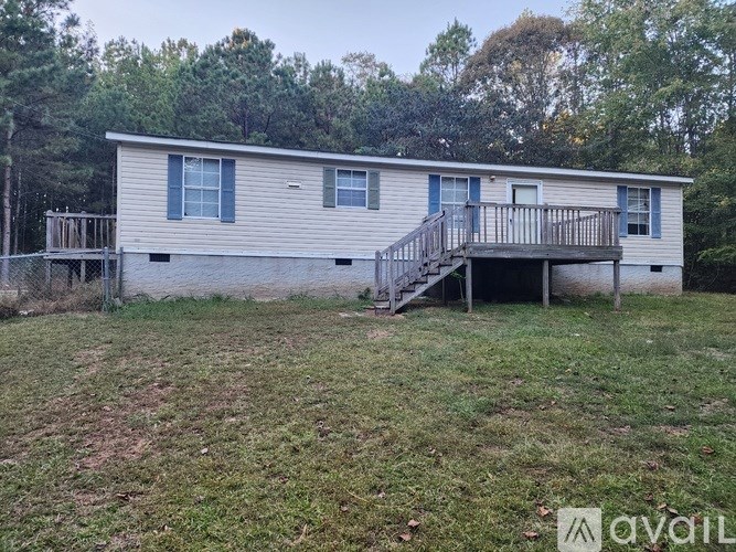 A two-story house with a deck and a fence.
