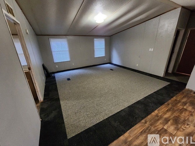 A room with a carpeted floor and a window.