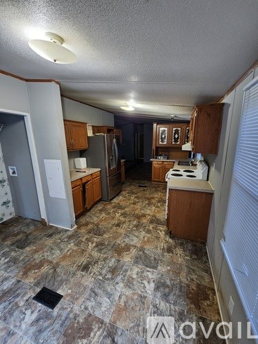 A kitchen with brown cabinets and a tiled floor.