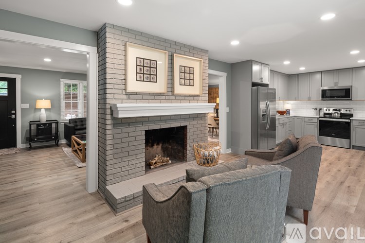 A modern living room with a fireplace and grey couches.